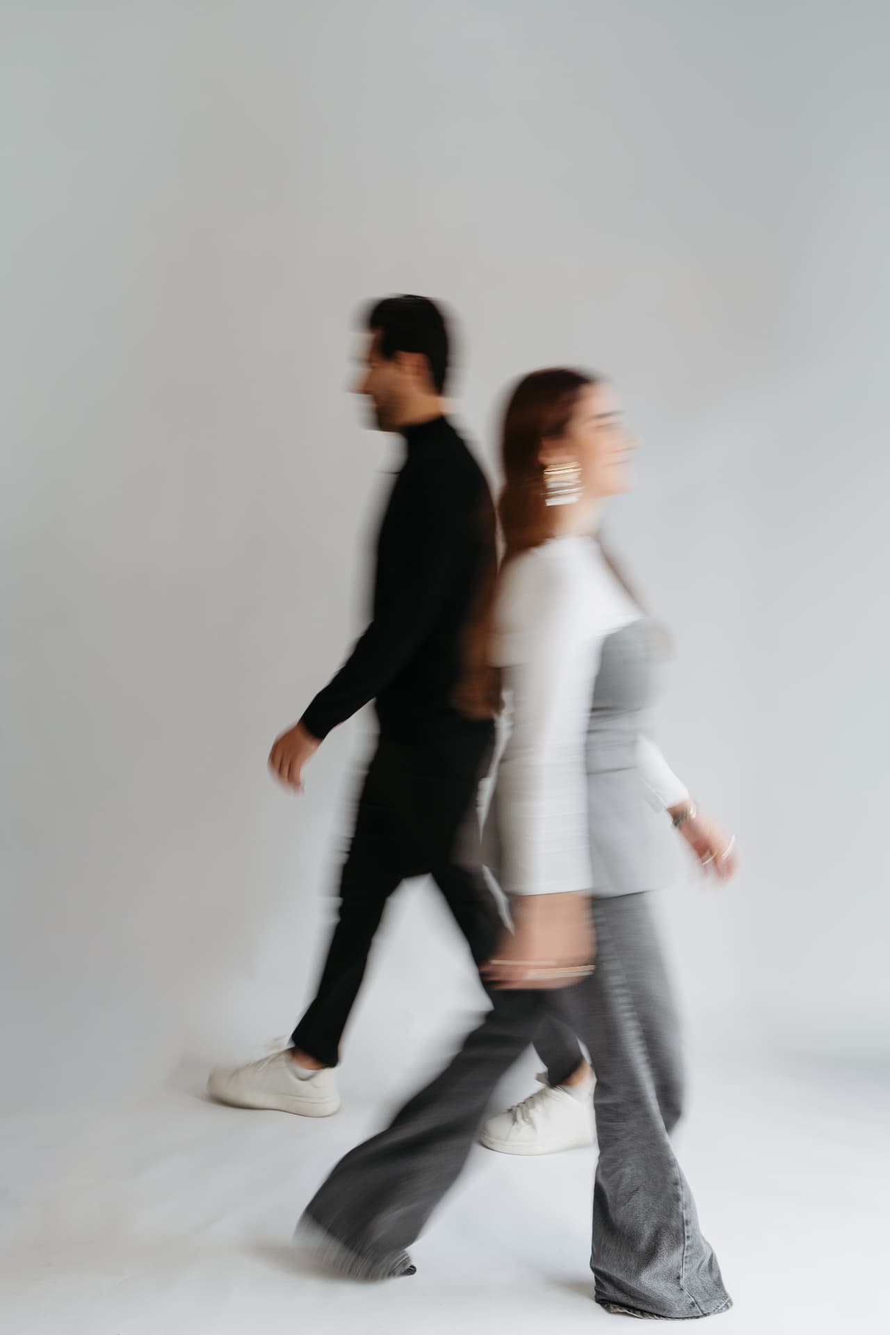 Duas pessoas caminhando em movimento, registro em preto e branco