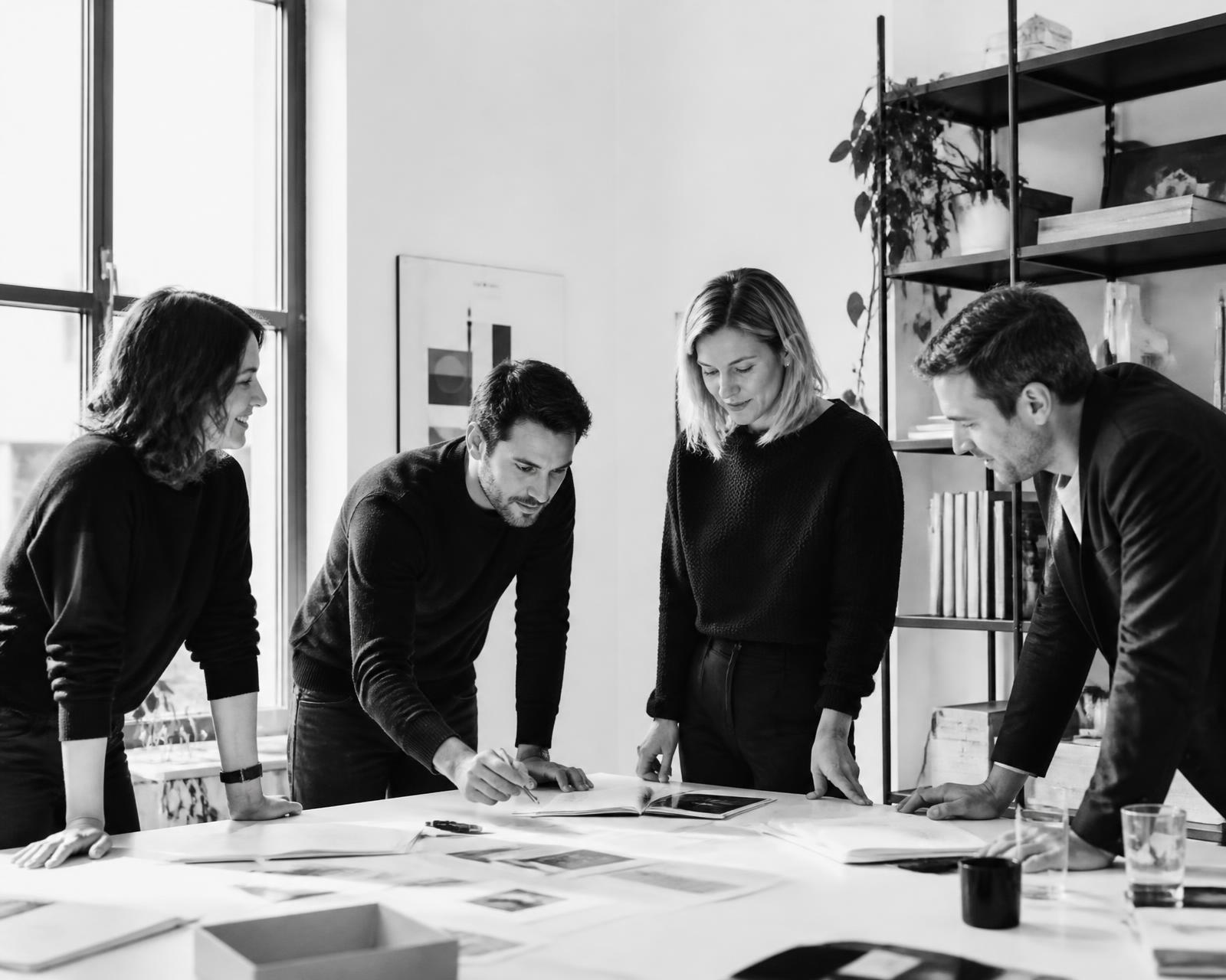 Equipe reunida em torno de uma mesa de trabalho